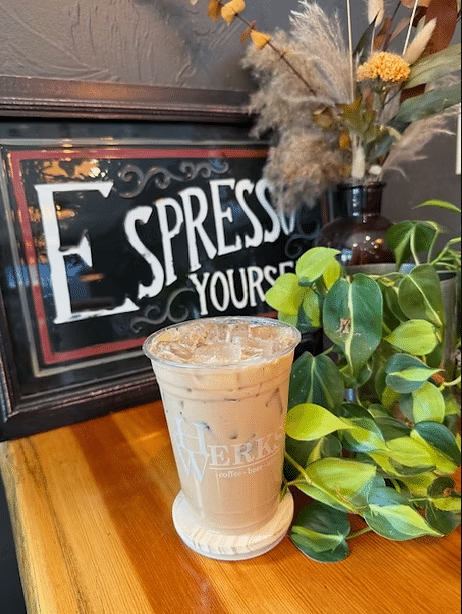 Iced coffee on wooden counter with cafe sign