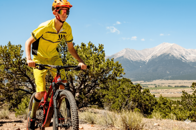 Boy mountain biking with mountains in background