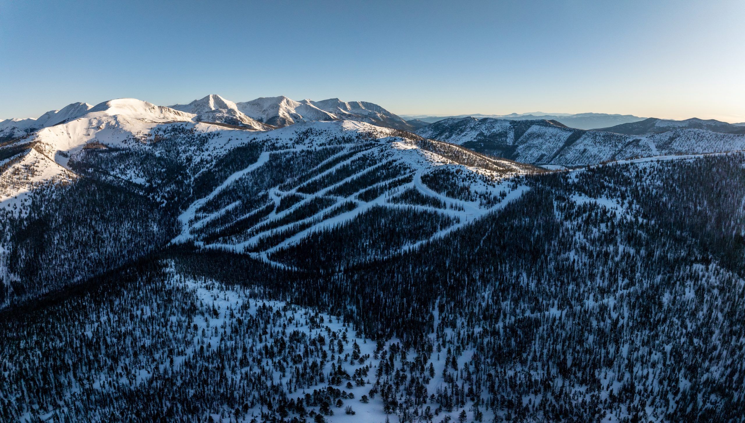 Snowy mountain ski slopes under blue sky.