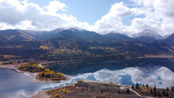 Snow-capped mountains reflected in a calm autumn lake
