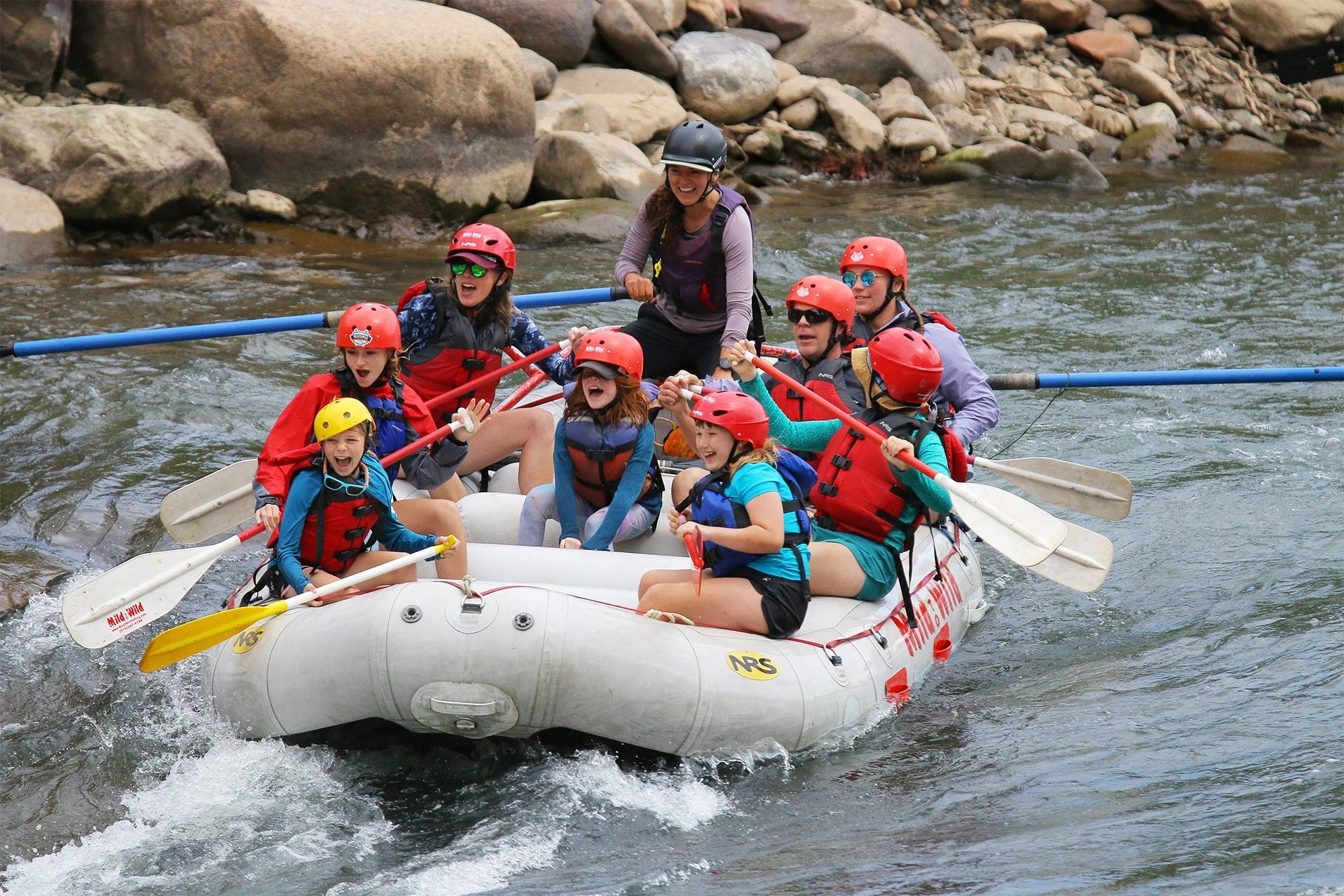 Group white-water rafting on rocky river