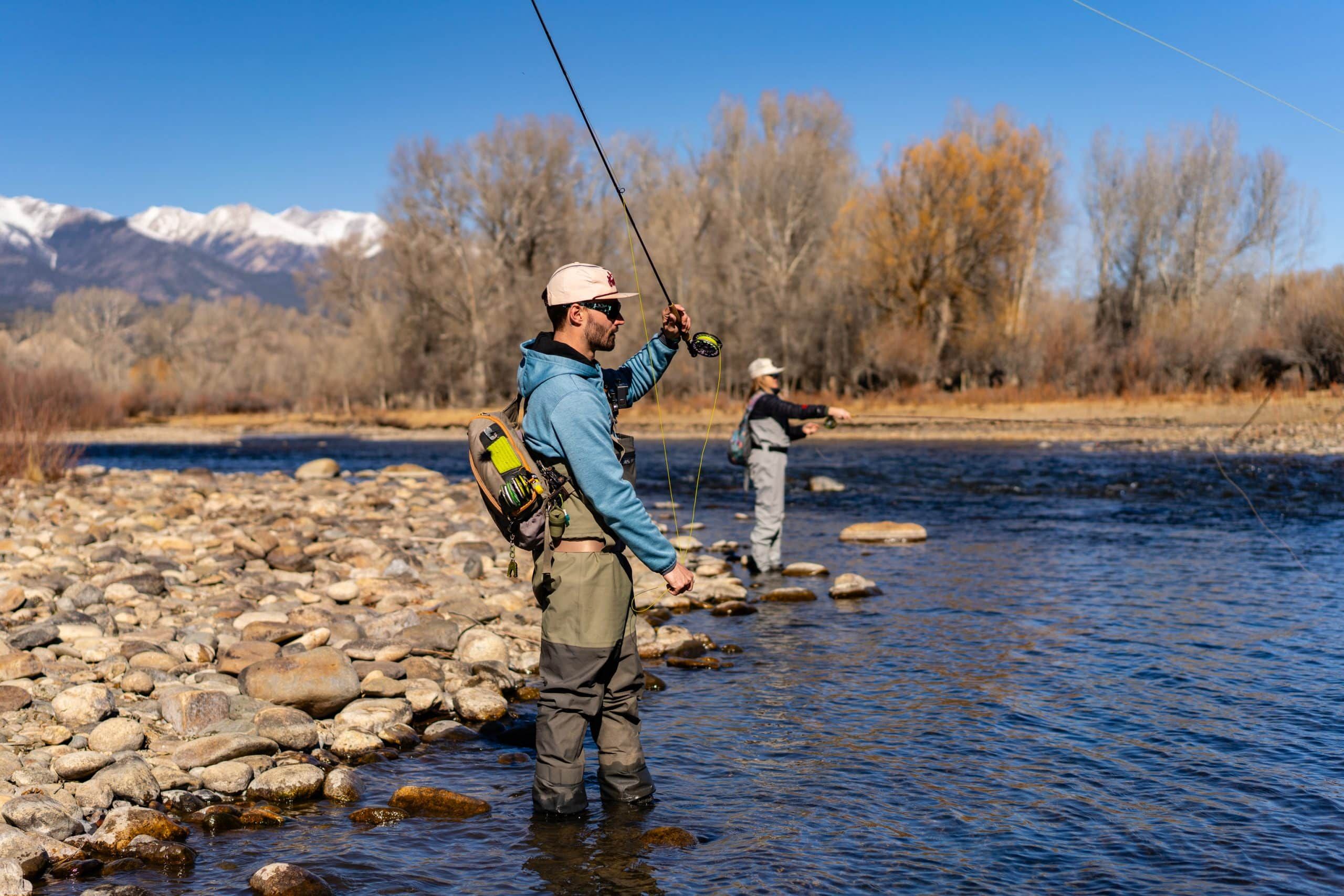 Two people fly fishing in mountain river