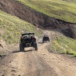 Two off-road vehicles on rugged dirt trail