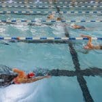 Swimmers doing freestyle in indoor lap pool