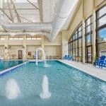 Indoor swimming pool with fountains and lounge chairs