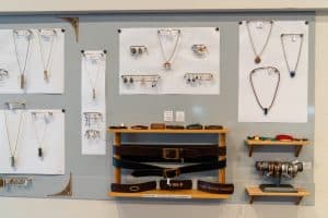 Jewelry and leather belts displayed on boutique wall