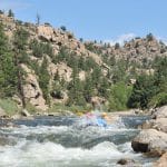 Whitewater rafting through rocky mountain river canyon